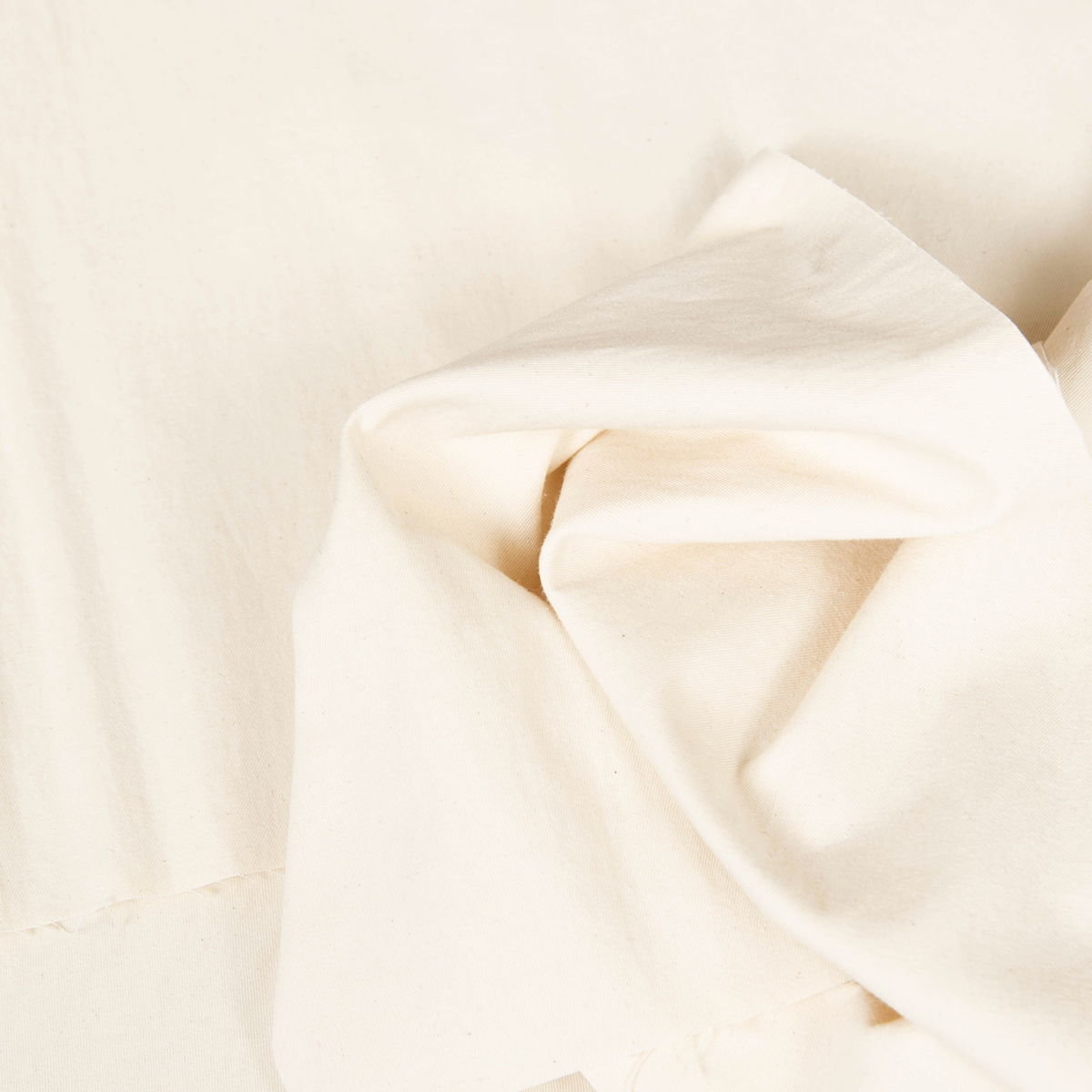 Gabardina di cotone lavato color crema venduta al metro, tessuto resistente e versatile per realizzare pantaloni chino, gonne e giacche eleganti.