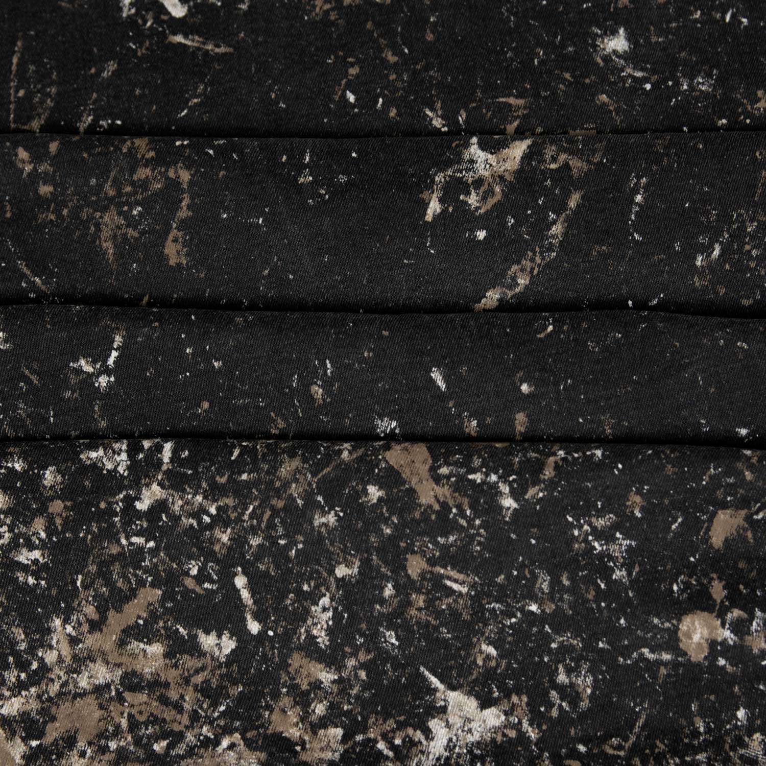 Gabardina di cotone stretch nera con stampa irregolare nei toni beige e bianco, effetto marmorizzato. Tessuto resistente e compatto, ideale per capi urbani come pantaloni, gonne e giacche.
