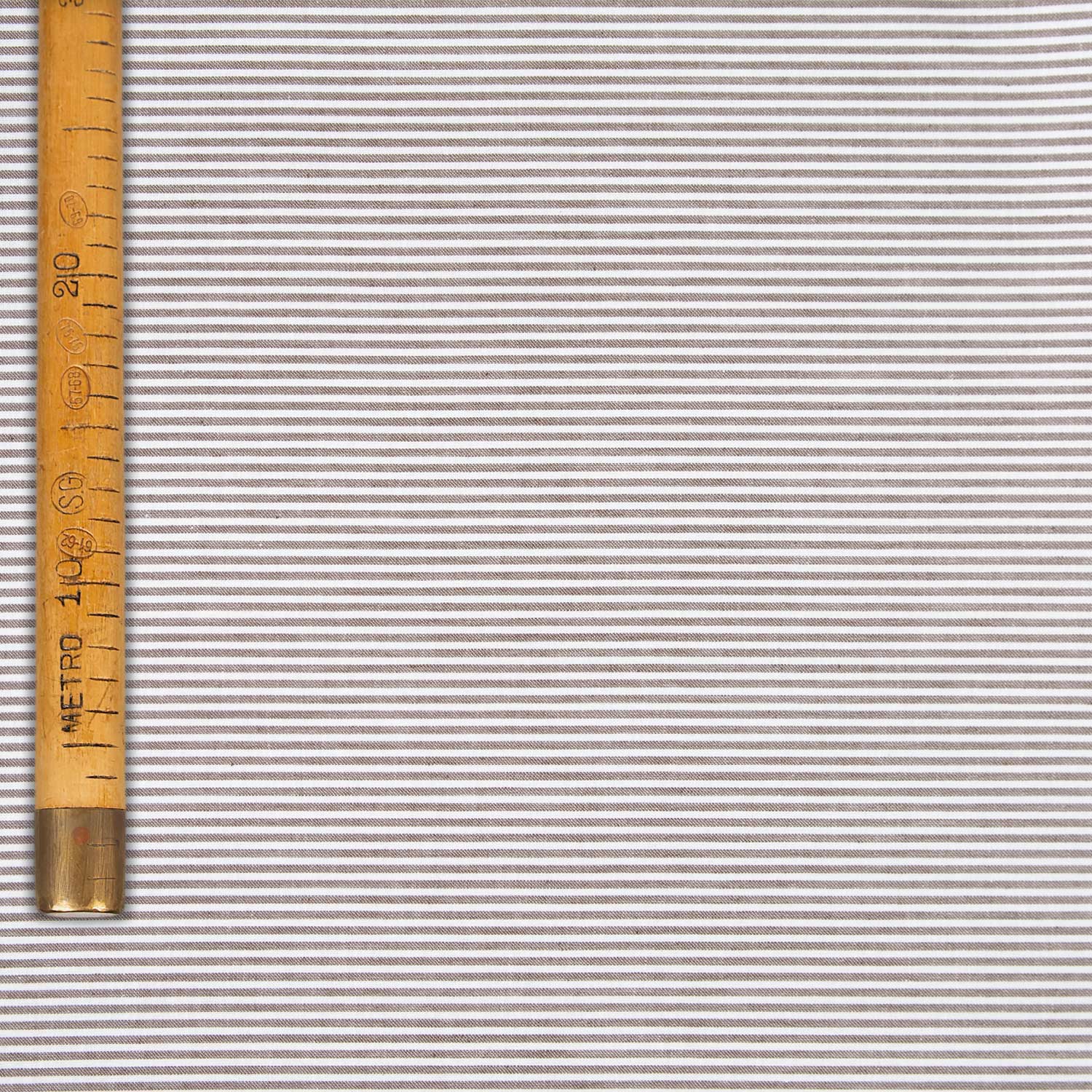 Tessuto in cotone panama tinta a filo marrone con bastoncino verticale e finissaggio washed.