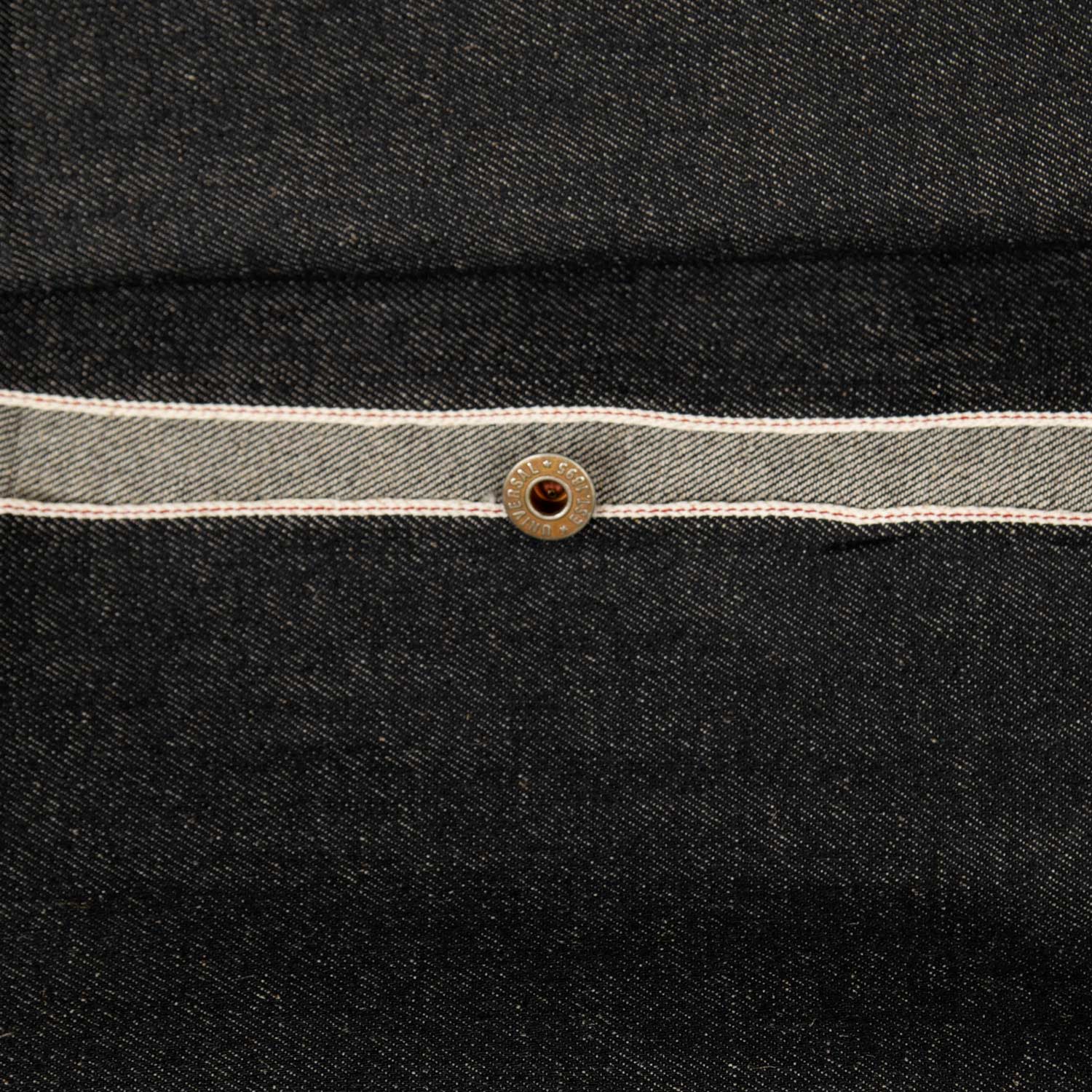 Dettaglio di tessuto denim selvedge nero giapponese raw denim con cimosa a vista, tessuto artigianale al metro