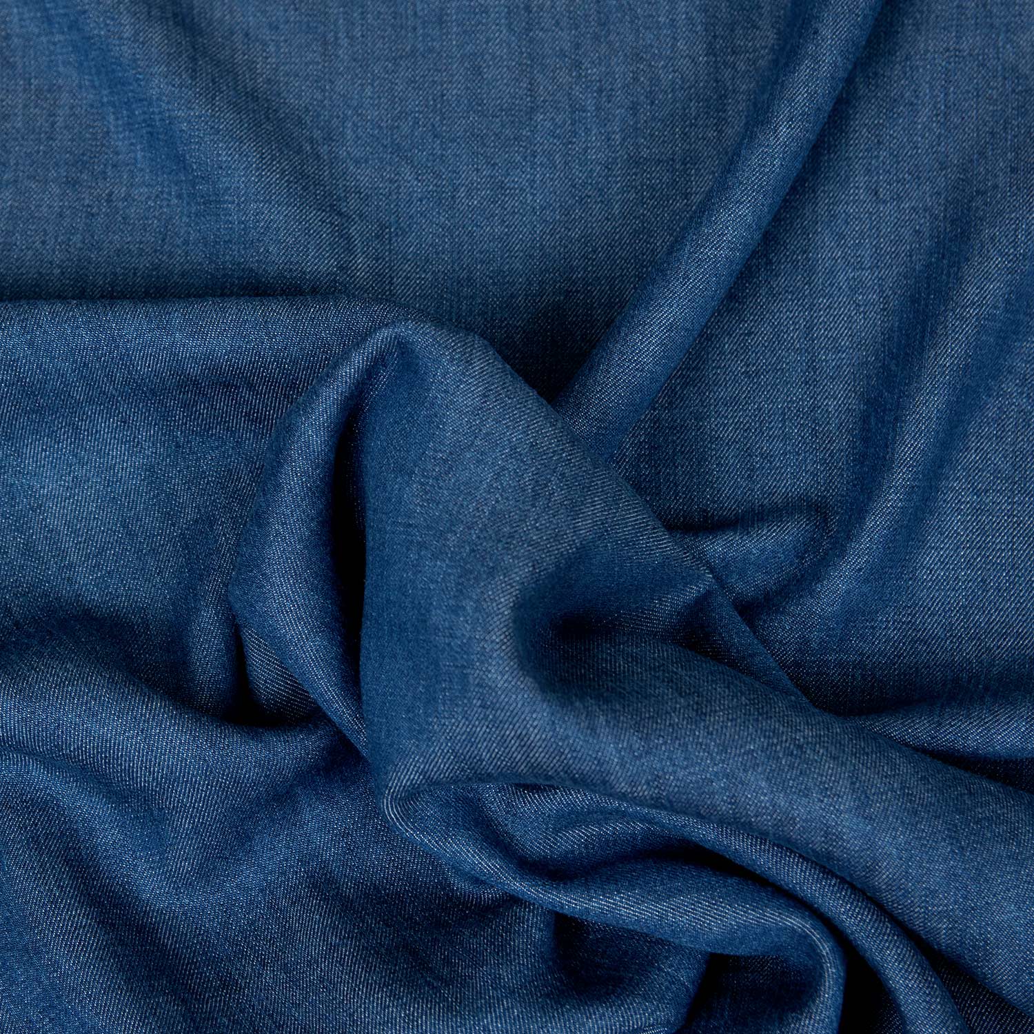 Dettaglio del tessuto Tencel Lyocell blu denim con elegante caduta naturale e mano compatta.
