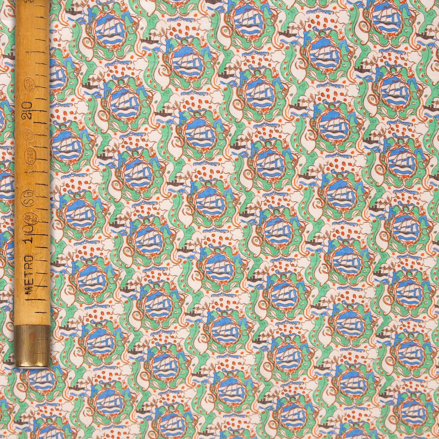 Raso leggero 30% seta 70% cotone con stampa dai motivi fantastici e sognanti in verde, azzurro e rosso su fondo beige, stoffa deadstock al metro.