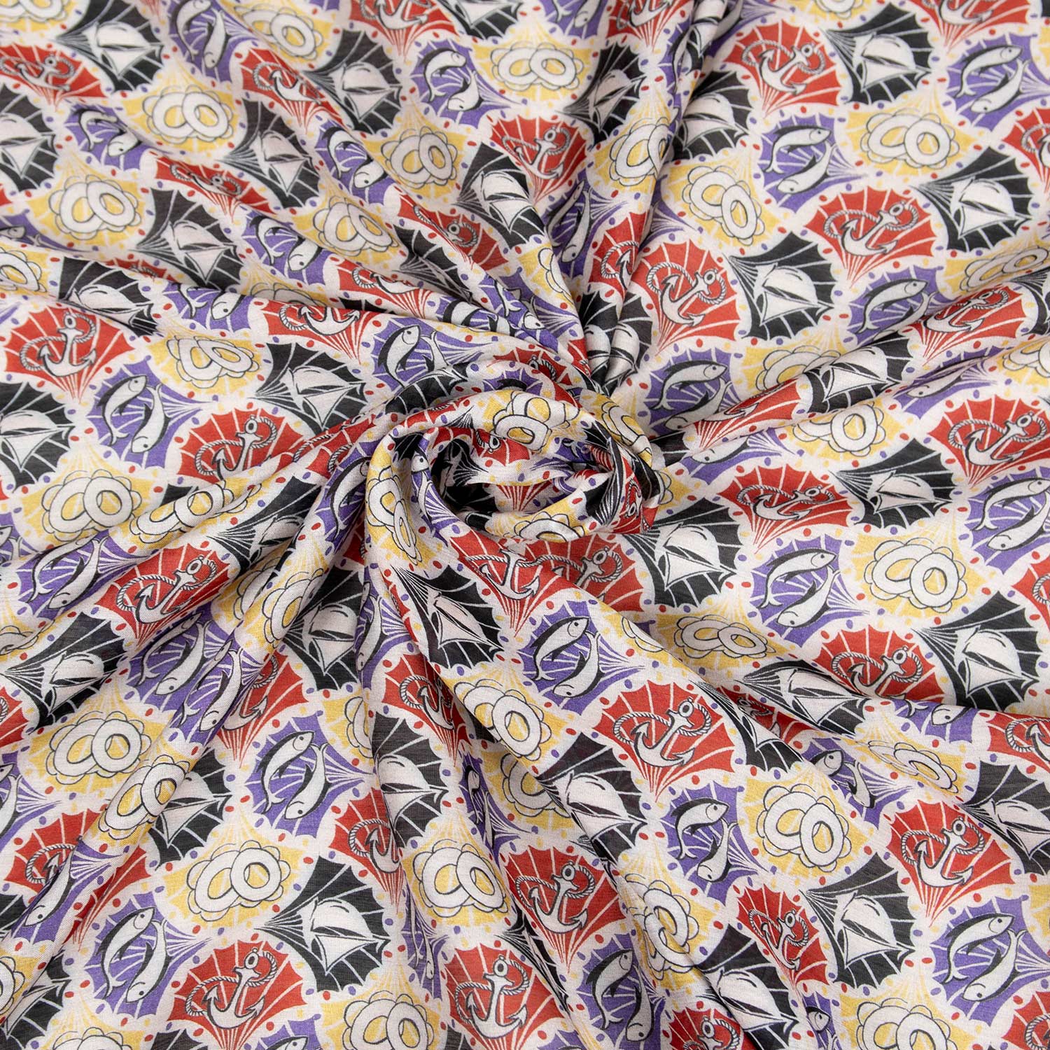 Tessuto charmeuse in raso leggero 70% cotone 30% seta con stampa marittima urbana di ancore, pesci e barche a vela in rosso, nero, giallo e viola, stoffa da abbigliamento deadstock made in Italy.