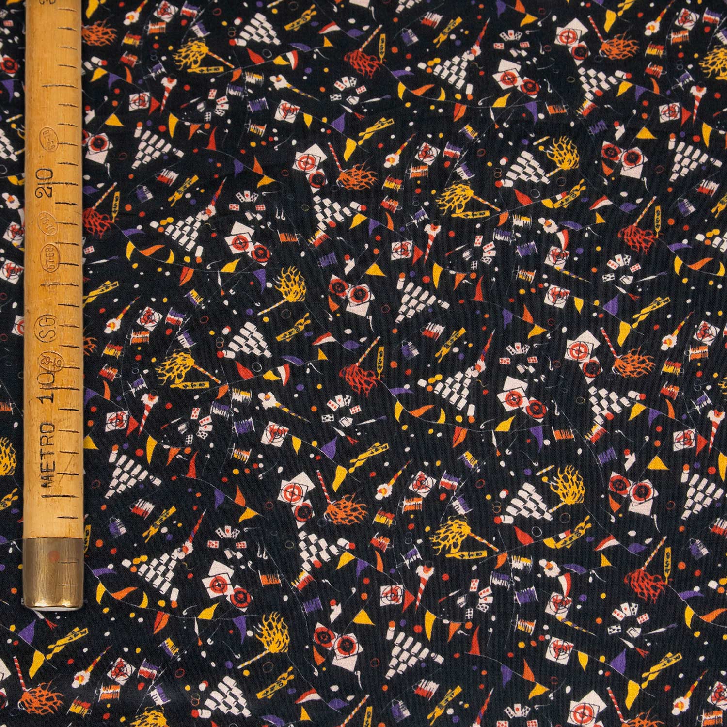 Deadstock tessuto charmeuse in raso 70% cotone 30% seta, fondo nero con piccoli disegni multicolor stampati a tema circo, morbido, lucido e venduto al metro, made in Italy.