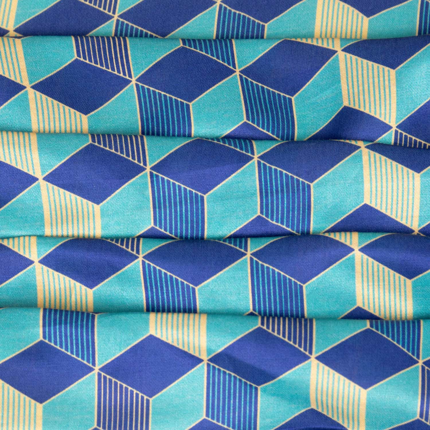 Stoffa da abbigliamento in raso charmeuse leggero con motivi geometrici nei toni del blu e beige, ideale per abiti, camicie, top e gonne eleganti.