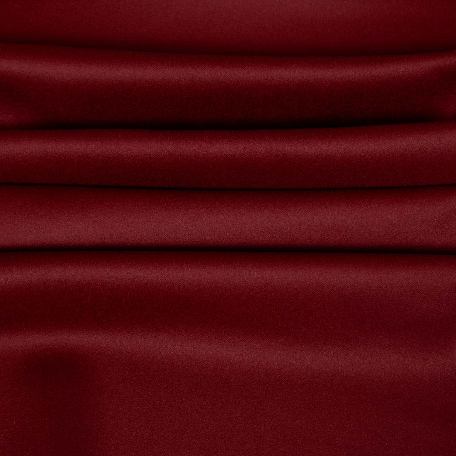 Primo piano di tessuto misto cashmere bordeaux deadstock, superficie liscia e compatta con riflessi caldi, ideale per cappotti e soprabiti invernali