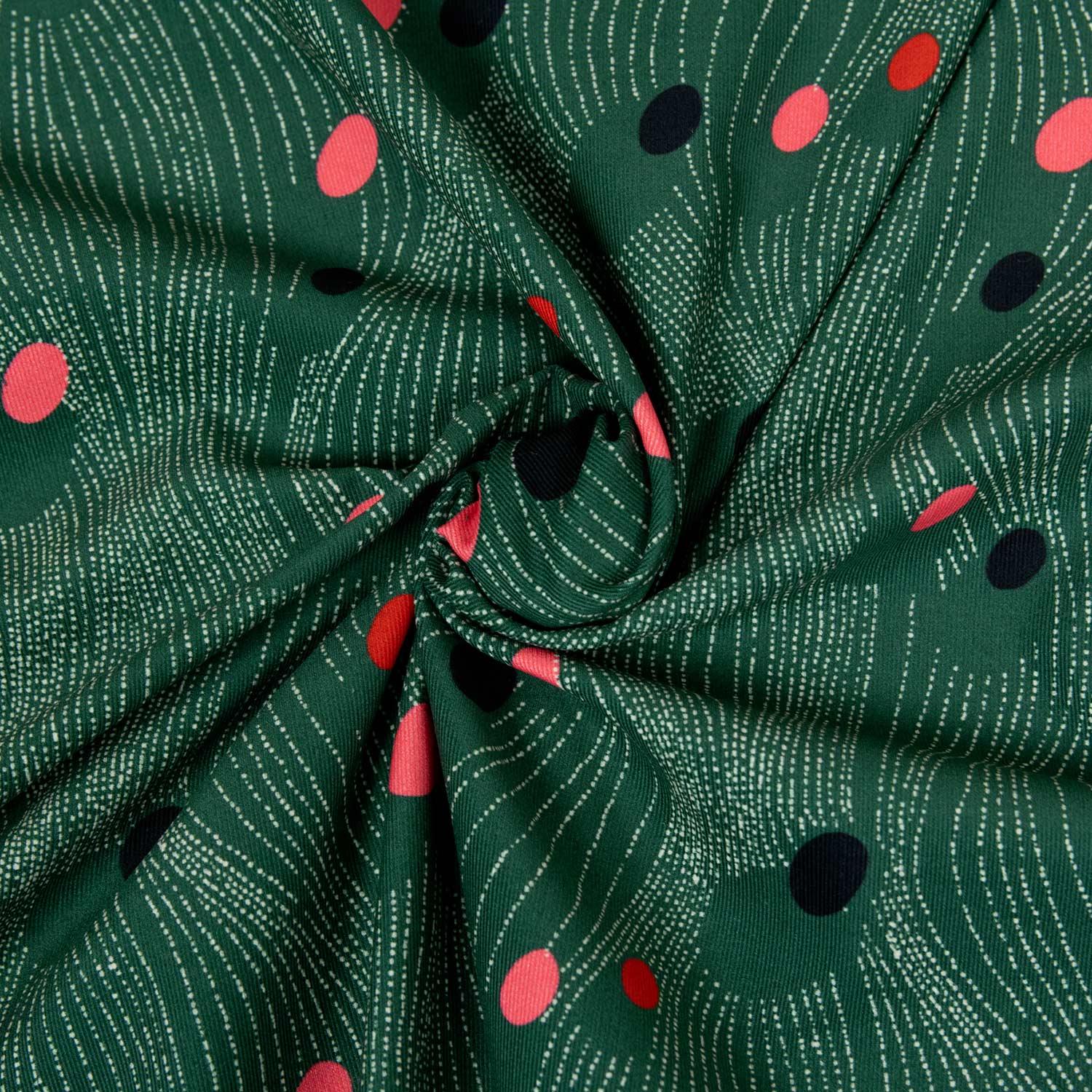 Velluto 100% cotone 2000 righe stampato deadstock luxury, fondo verde bosco con pattern geometrico astratto a dischi rosa, rosso e blu notte, tessuto arrotolato che mostra la morbidezza e la profondità cromatica del velluto pregiato