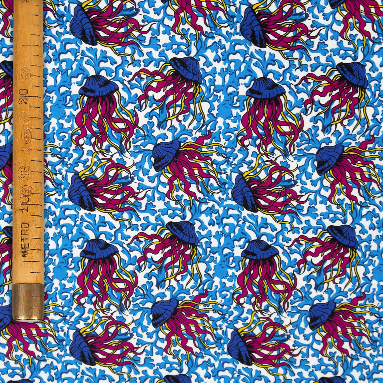 Mussola cotone deadstock con stampa meduse psichedeliche fucsia e blu su fondo bianco