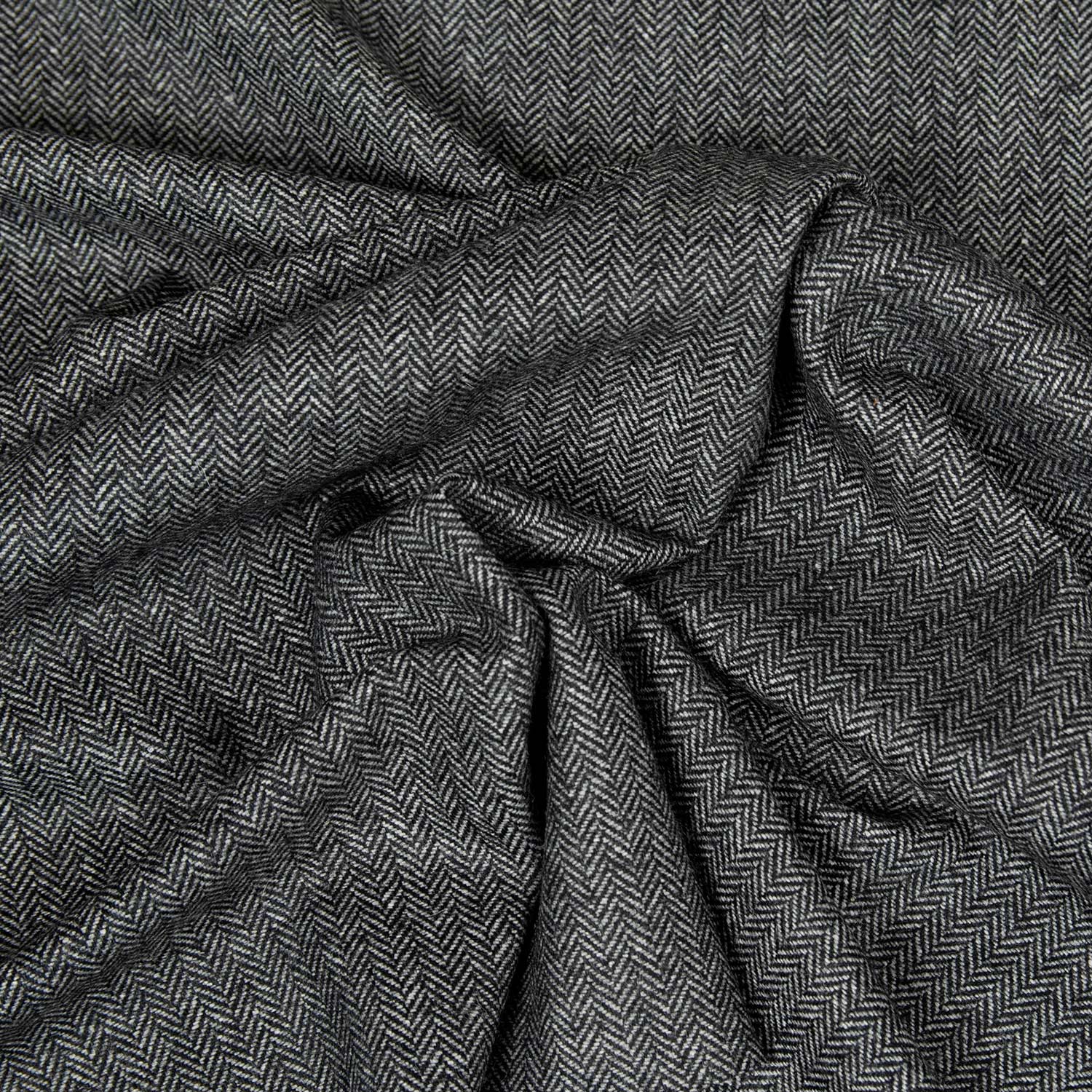 Primo piano del tessuto Herringbone grigio, lana riciclata di alta qualità con motivo chevron, perfetto per giacche, overshirt e blazer.