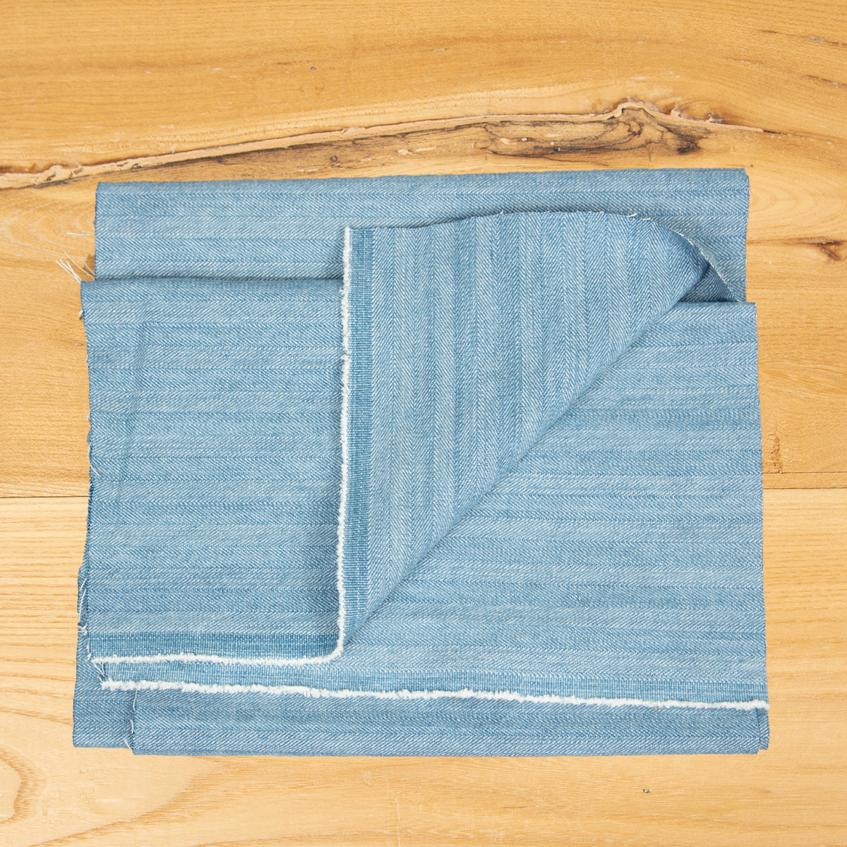Denim chiaro lavato 100% cotone con effetto rigato resca, tessuto jeans originale.