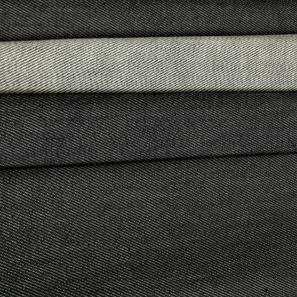 Tessuto jeans antracite elasticizzato non lavato, denim compatto disponibile in ampio metraggio.
